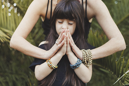 Girl meditating with mother